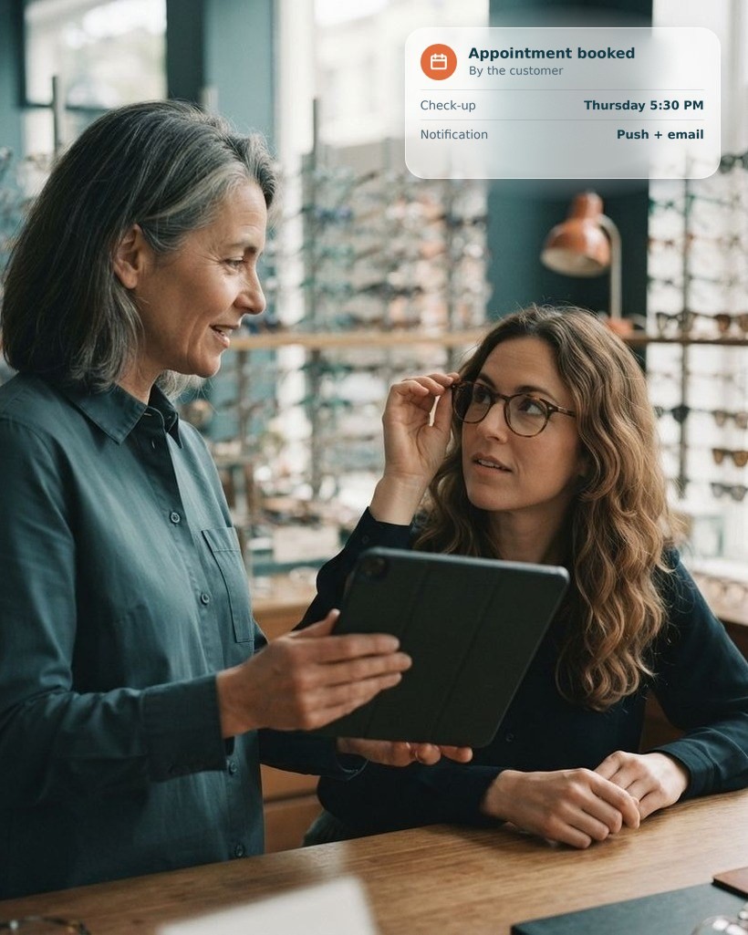 Optical store serving a customer with a tablet showing her profile, and a booked appointment card
